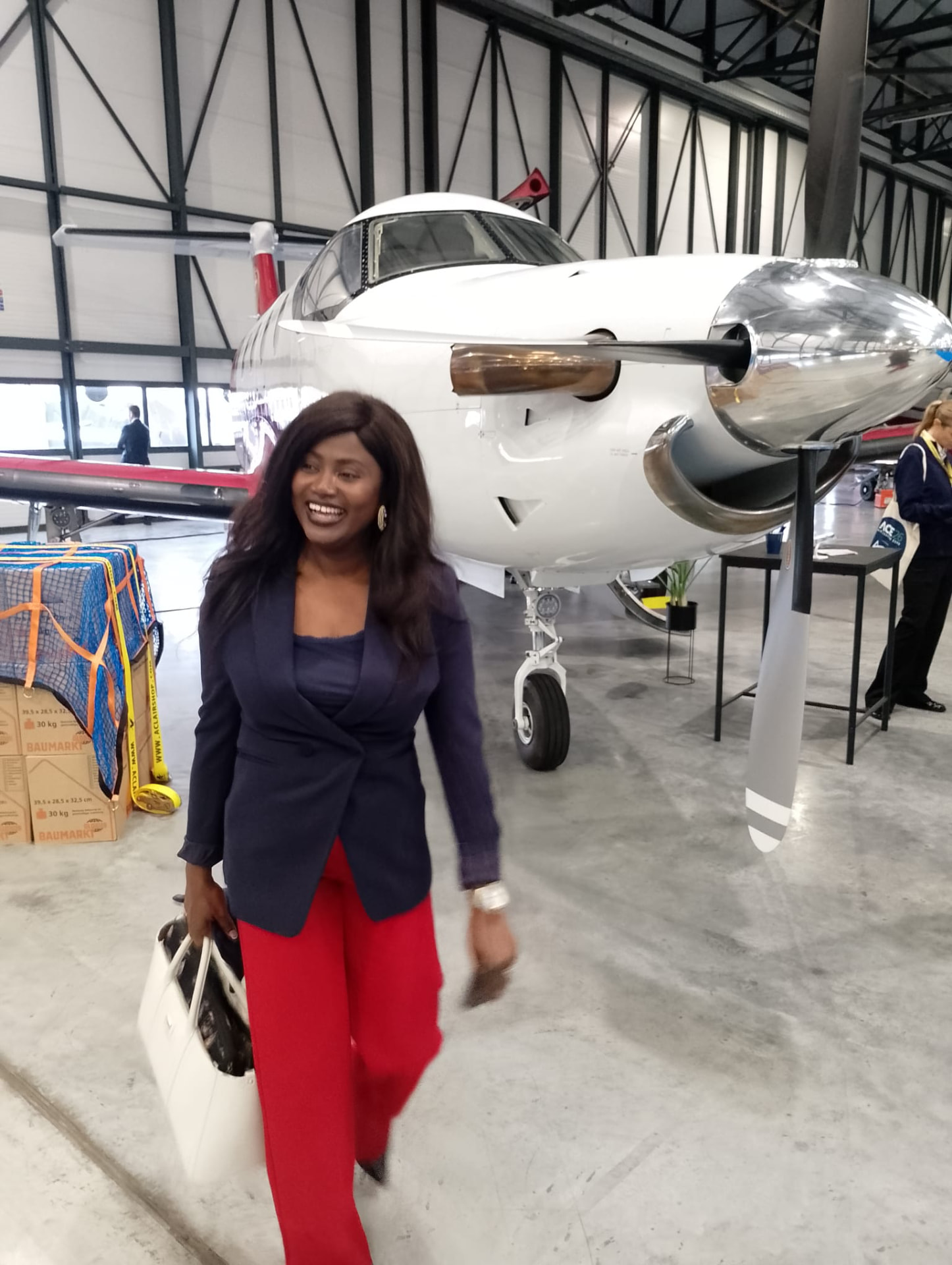 Kemi Areola walking through an aircraft hangar